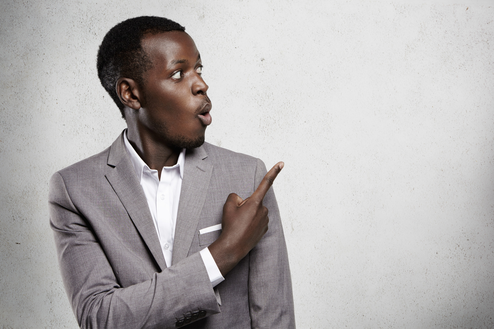 attractive-astonished-bug-eyed-dark-skinned-businessman-office-worker-formal-wear-looking-away-blank-wall-surprise-pointing-his-finger-copy-space-your-text-advertising-content_978.jpg